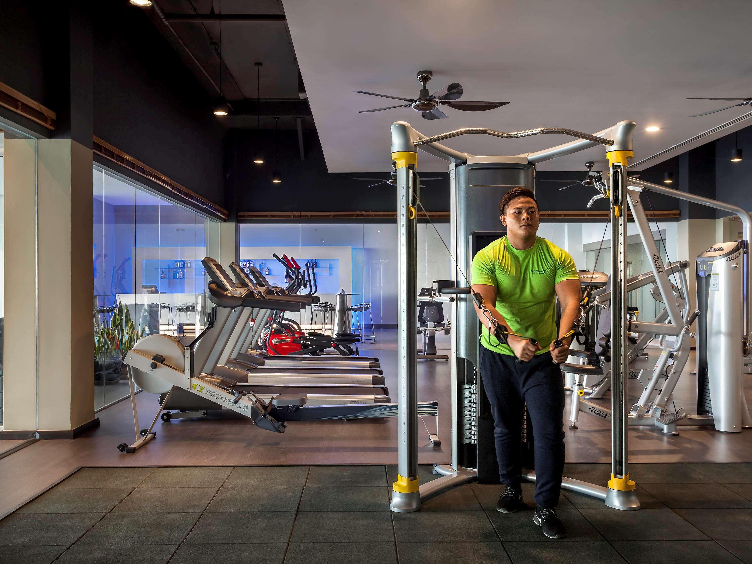 Pullman Miri Waterfront Hotel Kültér fotó A man doing dips on a parallel bar